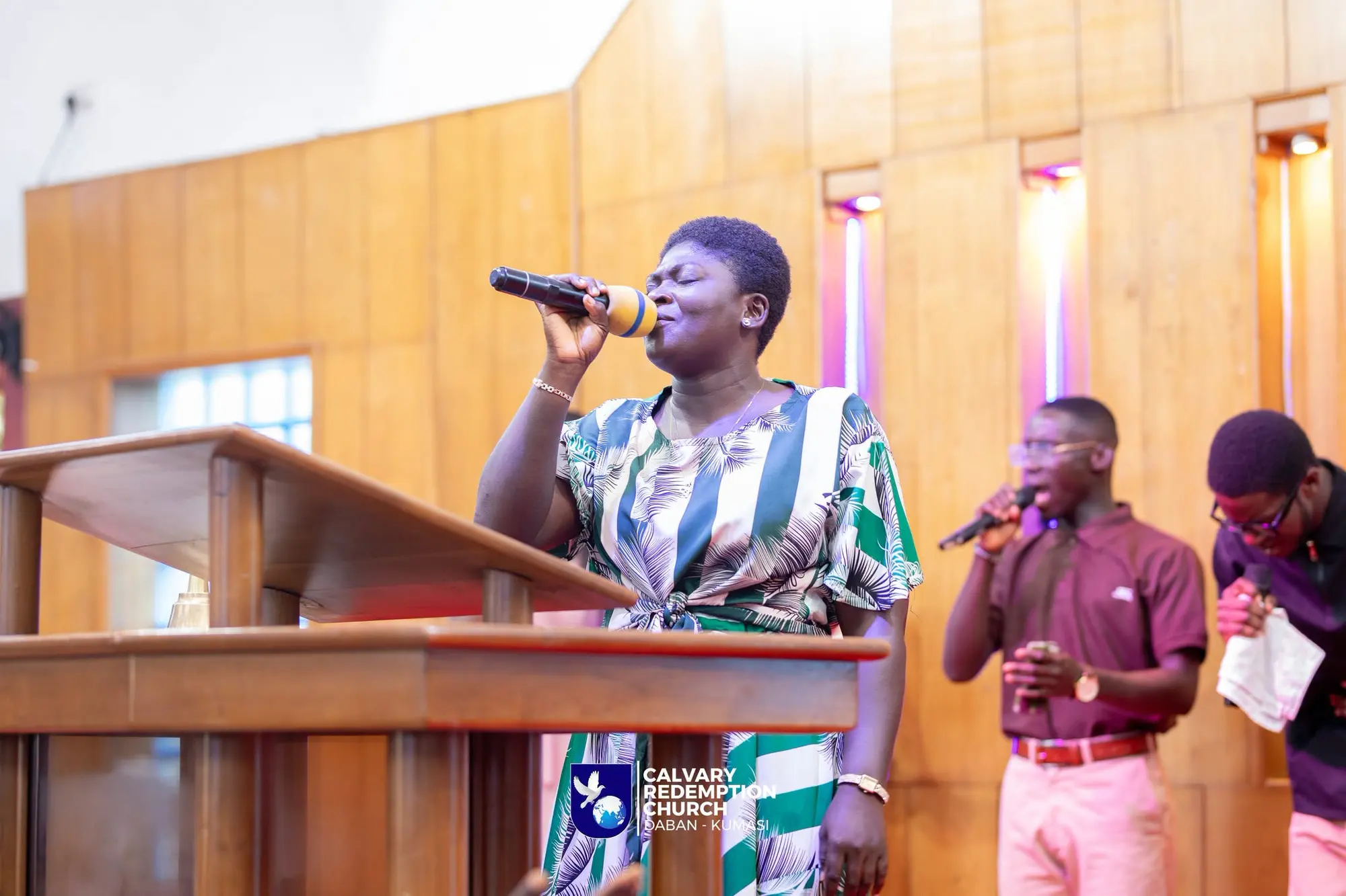 A worship leader singing at the pulpit